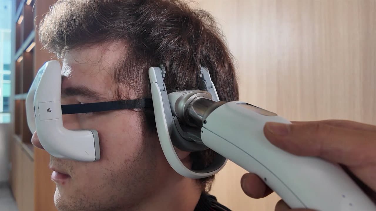An AI coach talks you through cutting your own hair, with a plastic band across your face one reviewer called 'extremely normal looking.'